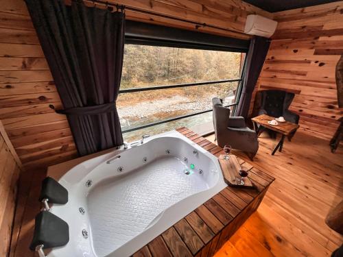 a bath tub in a room with a large window at Medi Soho Bungalov in Rize