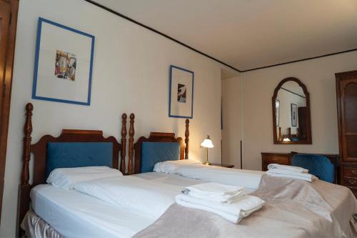 two twin beds in a bedroom with a mirror at Hotel Petit Wannsee in Berlin