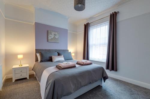 a bedroom with a large bed and a window at Sandy House in Scarborough