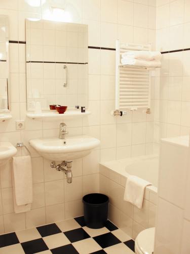 a bathroom with a sink and a toilet and a tub at Hotel Boer Goossens in Den Dungen
