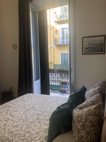 Un dormitorio con una cama y vista a un balcón. en La Bella Balla-rò Rooms, en Palermo