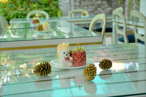 a plate with a teddy bear on a table with pine cones at Negombo New Queen's Palace in Negombo