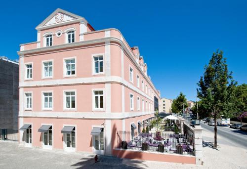 um edifício cor-de-rosa com uma torre de relógio em cima em SANA Silver Coast Hotel nas Caldas da Rainha