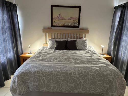 ein Schlafzimmer mit einem großen Bett mit zwei Lampen in der Unterkunft Sandy Shores 3 Henties in Henties Bay