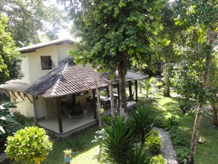 a small house in the middle of a garden at Pousada Namuncurá in Arraial d'Ajuda