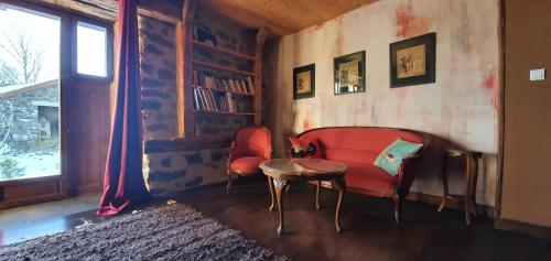 La chambre d'hôte du Petit Mazilloux في Présailles: غرفة معيشة مع كرسي احمر وطاولة
