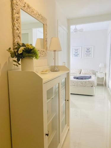 een kamer met een wastafel met een spiegel en een bed bij Town Apartment direkt im Zentrum von Denia in Denia