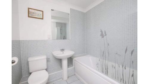 a white bathroom with a sink and a toilet and a tub at Beautiful Apartment Central Oxford in Oxford