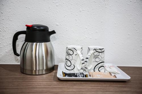 een koffiepot en een bord met een waterkoker bij New Dawn Hotel Pontian Sdn Bhd in Pontian Kecil