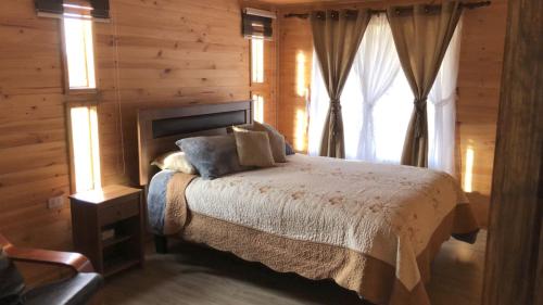 1 dormitorio con 1 cama en una cabaña de madera en casa completamente equipada, a pasos de Tijeral, Renaico y Angol, en Renaico