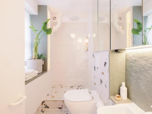 a white bathroom with a toilet and a sink at Pass the Keys Designer Apartment in the heart of Euston in London