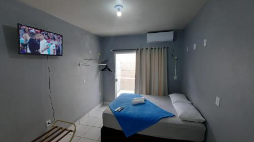 1 dormitorio con 1 cama con pared azul en Estúdios Individual na Meia Praia ar, wifi, vaga, cozinha, tv smart - 6 x no cartão sem juros, en Itapema
