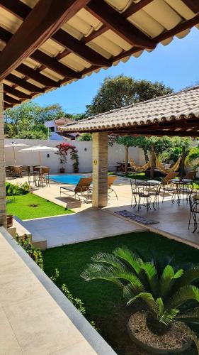 eine Terrasse mit Tischen und Stühlen unter einem Pavillon in der Unterkunft Pousada Vila Santa Maria in Pirenópolis