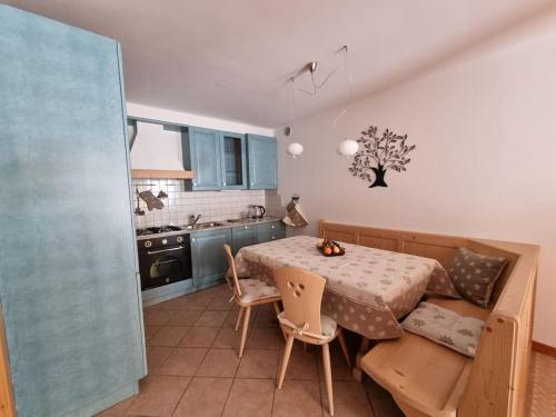 uma cozinha com mesa e cadeiras num quarto em Appartamento ai larici, rustico ed elegante em Varena
