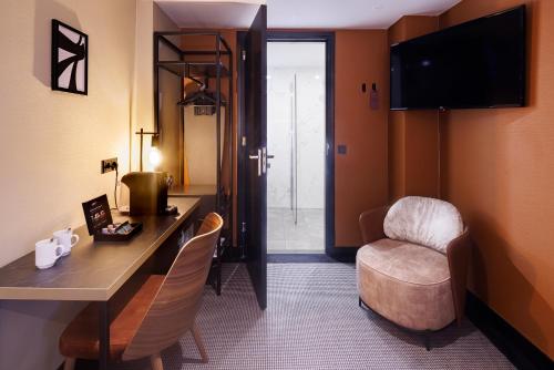 a hotel room with a desk and a chair at Huygens Place Amsterdam in Amsterdam