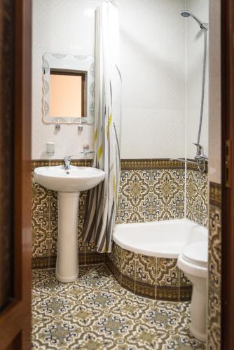 a bathroom with a sink and a tub and a toilet at Hotel Ravshan Boutique in Bukhara