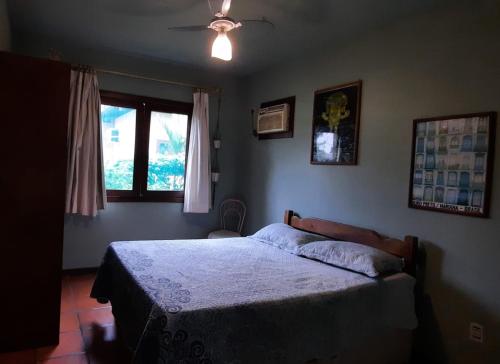 um quarto com uma cama e uma janela em Paz Mania em Porto Seguro