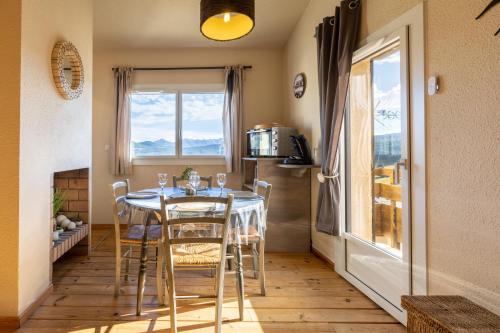 une salle à manger avec une table et des chaises et une fenêtre dans l'établissement La Minoterie, aux Angles