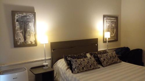 sypialnia z łóżkiem z poduszkami i 2 lampami w obiekcie Loft Rufino w mieście Mendoza