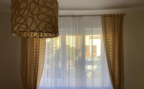 a window with curtains and a lamp in a room at Apartmán 551 in Litomyšl