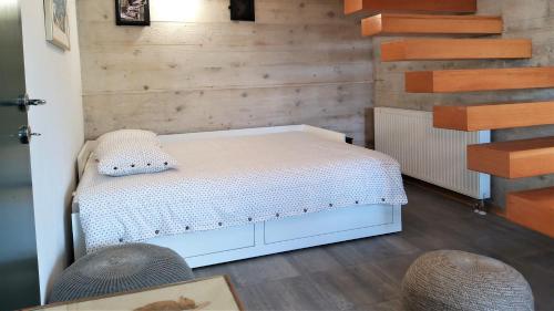 a bedroom with a white bed and wooden walls at Villa Bornstein in Korenica