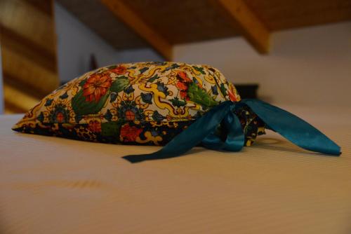 a hat with a blue ribbon sitting on a bed at VILLA VICINUS - 120 mq - parking - garden in Vietri sul Mare