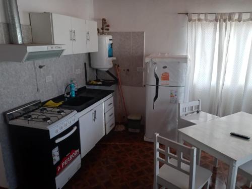 a small kitchen with a stove and a refrigerator at Departamento Asaï Malargüe in Malargüe