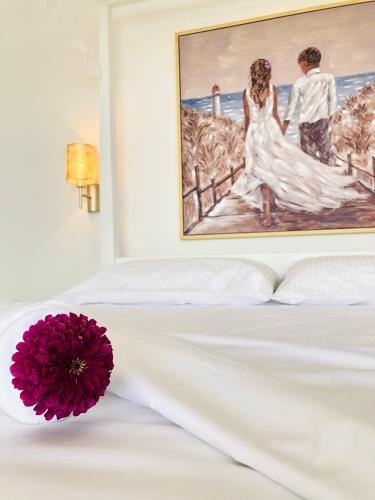 a white bed with a picture of a bride and groom at Fogo Boutique Hotel in São Filipe