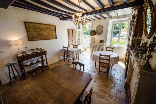 una sala con tavolo e sedie e una sala da pranzo di Ferme du Loucel a Colleville-sur-Mer