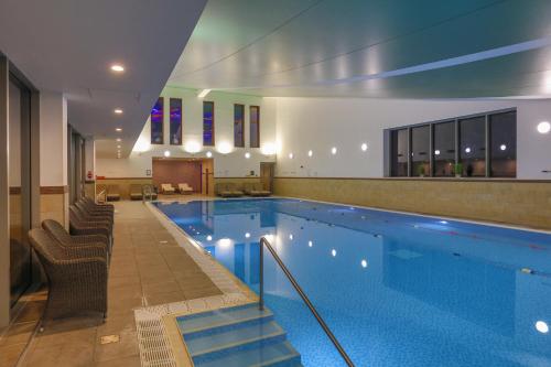 a large swimming pool with chairs at Crewe Hall Hotel & Spa - Cheshire in Crewe