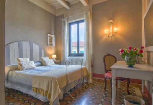 1 dormitorio con cama, mesa y ventana en B&B Il Malconsiglio, en Pistoia