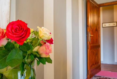 a vase filled with roses in a room at Il Malconsiglio in Pistoia