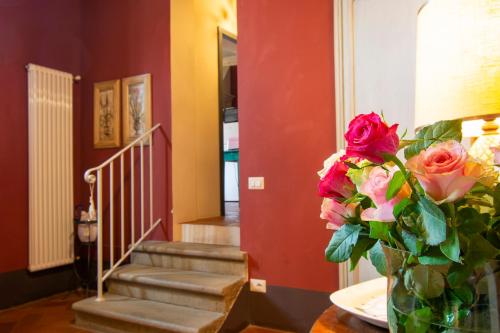 a vase with roses on a table in a room at Il Malconsiglio in Pistoia