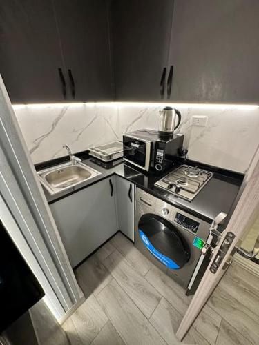 eine kleine Küche mit einer Spüle und einer Mikrowelle in der Unterkunft privet (33)near downtown kh&sh in Ash Shumaysānī