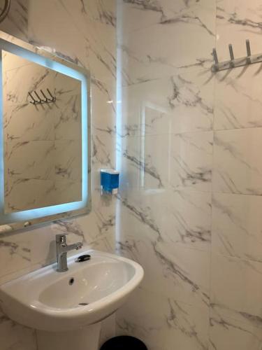 La salle de bains blanche est pourvue d'un lavabo et d'un miroir. dans l'établissement privet (33)near downtown kh&sh, à Ash Shumaysānī