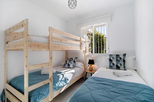 a bedroom with two bunk beds and a window at Apartamento Calas Sancti Petri in Novo Sancti Petri