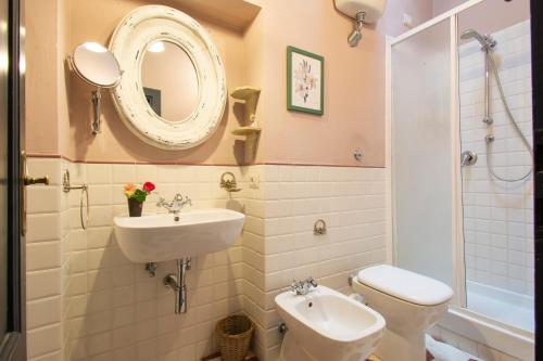 a bathroom with a sink and a toilet and a mirror at Il Malconsiglio in Pistoia