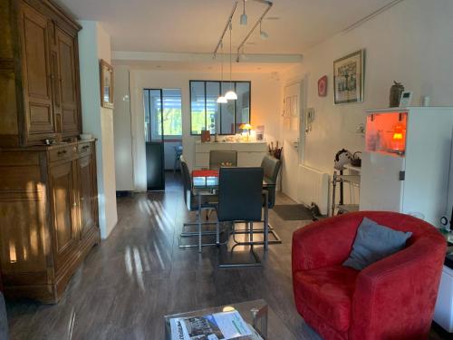 a living room with a red chair and a kitchen at Mes Oasis Nancy in Villers-lès-Nancy