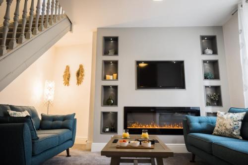 a living room with two blue couches and a fireplace at The Old Packhorse in Staindrop