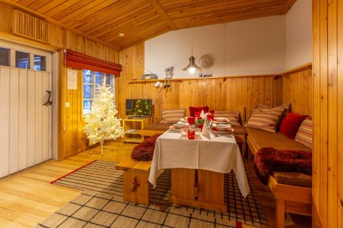a dining room with a table and a christmas tree at Kuukkeli Apartments Tokka in Saariselka