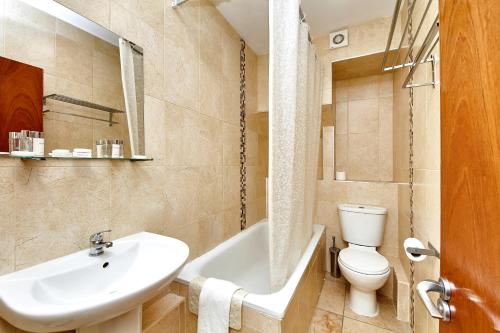 a bathroom with a sink and a toilet and a bath tub at United Lodge Hotel in London
