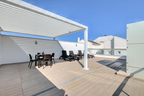 a patio with a table and chairs on a roof at Aqua Apartments Vento, Marbella in Marbella