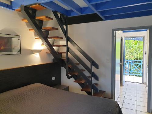 een slaapkamer met een wenteltrap met blauwe plafonds bij Aquabeach in La Saline les Bains