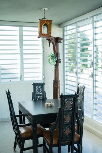 a dining room table and chairs with a clock on the wall at La Esmeralda PR in San Juan