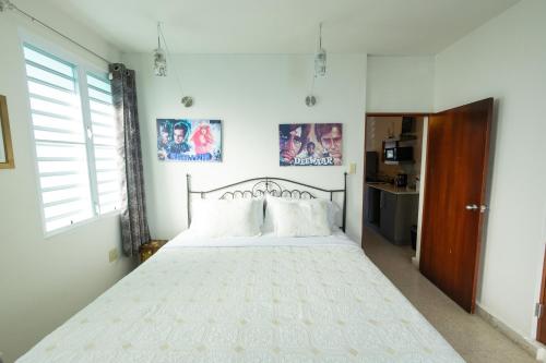 a bedroom with a large white bed with two pillows at La Esmeralda PR in San Juan