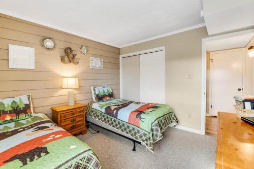 a bedroom with two beds and a table with a lamp at Mountain Top Retreat in Gatlinburg