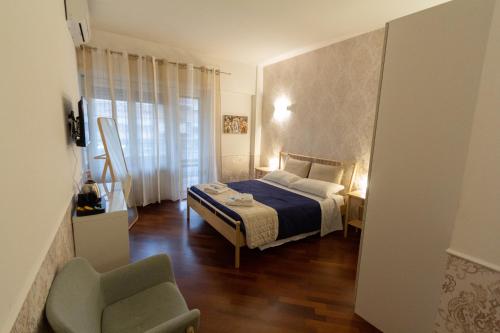 Un pequeño dormitorio con una cama y una silla. en Aurelio Deluxe Rooms, en Roma