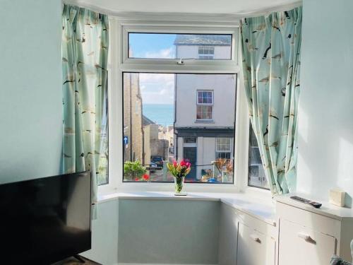 a window with a vase of flowers on a window sill at Kearney Cottage - Artist's Retreat in Portland