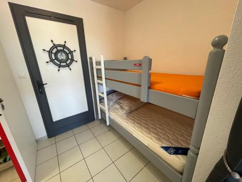 a small room with a bunk bed and a mirror at Le Surf in Mimizan-Plage