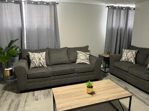 a living room with a couch and a coffee table at Cozy Modern and Lavish 1 Bedroom Basement Suite in Winnipeg